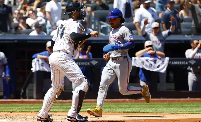 New York Mets' Francisco Lindor (12) scores a run against the New York Yankees during the fourth inning of a baseball game, Saturday, May 17, 2025, in New York. (AP Photo/Noah K. Murray)