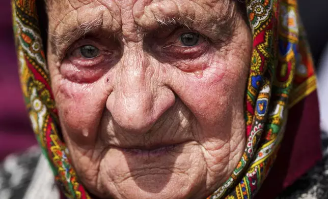 A woman cries during a funeral ceremony for Tamara Martyniuk, 8, Stanislav Martyniuk, 12, and Roman Martyniuk, 17, killed in a Russian strike on Sunday, in Korostyshiv, Zhytomyr region, Ukraine, Wednesday, May 28, 2025. (AP Photo/Evgeniy Maloletka)