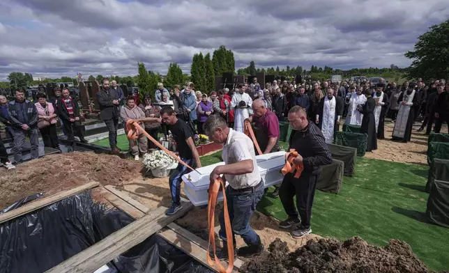 Funeral workers carry the coffin of Tamara Martyniuk, 8, killed in a Russian strike on Sunday together with Stanislav Martyniuk, 12, and Roman Martyniuk, 17, during a funeral ceremony in Korostyshiv, Zhytomyr region, Ukraine, Wednesday, May 28, 2025. (AP Photo/Evgeniy Maloletka)