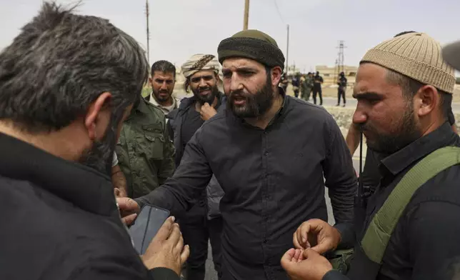 Sheikh Laith al-Balous, centre, a Druze leader in the southern Sweida province, speaks with Sweida governor Mustafa al-Bakour, left, at a highway where they found bodies of Syrian Druze fighters who were in a convoy heading from the southern Sweida province towards the capital to support their people, at al-Sor al-Kobra village, southern Syria, Thursday, May 1, 2025. (AP Photo/Omar Albam)