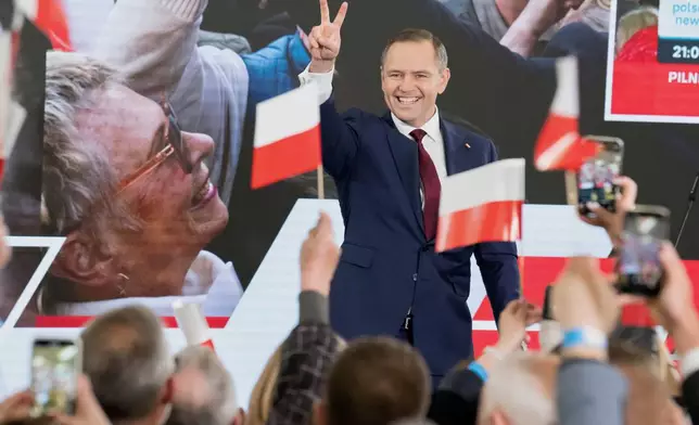 Karol Nawrocki, presidential candidate for the 2025 Polish presidential election supported by Poland's national conservative Law and Justice party, wave to supporters as first exit polls following the presidential elections are announced in Gdansk, Poland, Sunday, May 18, 2025. ( AP Photo/Wojciech Strozyk)