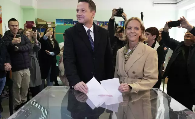 Presidential candidate, Warsaw's Mayor and member of ruling centrist Civic Coalition party Rafal Trzaskowski and his wife Malgorzata Trzaskowska cast their ballots at a polling station in Warsaw, Sunday, May 18, 2025. (AP Photo/Czarek Sokolowski)