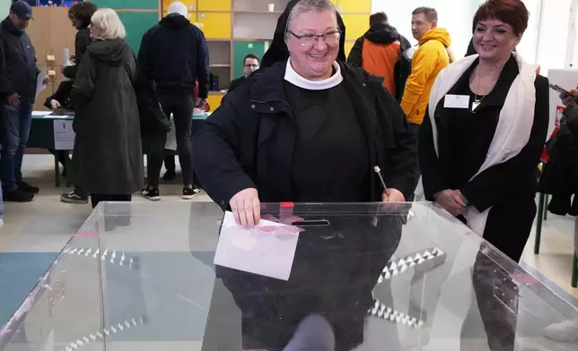 A voter casts her ballot at a polling station in the first round of Poland's presidential elections in Warsaw, Poland, Sunday, May 18, 2025. (AP Photo/Czarek Sokolowski)