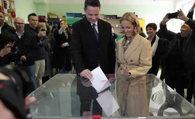 Presidential candidate, Warsaw's Mayor and member of ruling centrist Civic Coalition party Rafal Trzaskowski and his wife Malgorzata Trzaskowska cast their ballots at a polling station in Warsaw, Sunday, May 18, 2025. (AP Photo/Czarek Sokolowski)