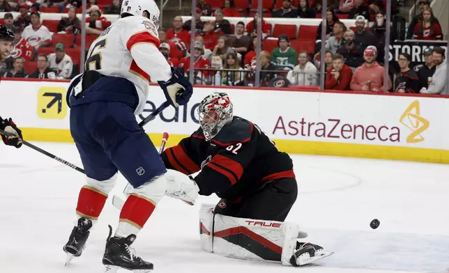 Florida Panthers' Aleksander Barkov (16) tips the puck past Carolina Hurricanes goaltender Pyotr Kochetkov (52) for a goal during the third period of Game 2 of the NHL hockey Stanley Cup Eastern Conference finals in Raleigh, N.C., Thursday, May 22, 2025. (AP Photo/Karl DeBlaker)