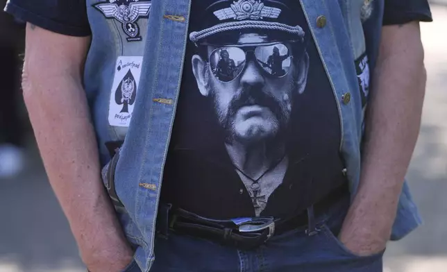 A Fan wears a T-Shirt with a picture of singer Lemmy Kilmister to commemorate the Motorhead frontman in Burslem, Stoke on Trent, England, Friday, May 9, 2025. The musician, once described as having 'one of the most recognizable voices in rock', was born in Burslem and a statue has been crafted by acclaimed local sculptor and lifelong Motorhead fan Andy Edwards. (AP Photo/Kirsty Wigglesworth)