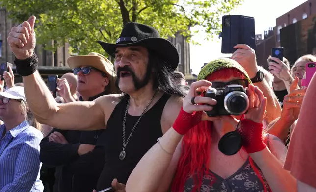 Motorhead fans gather to commemorate Lemmy Kilmister the Motorhead frontman in Burslem, Stoke on Trent, England, Friday, May 9, 2025. The musician, once described as having 'one of the most recognizable voices in rock', was born in Burslem and a statue has been crafted by acclaimed local sculptor and lifelong Motorhead fan Andy Edwards. (AP Photo/Kirsty Wigglesworth)