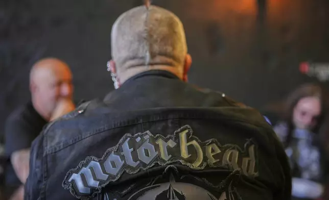 A Motorhead fan sits in a pub as fans gather to commemorate Lemmy Kilmister the Motorhead frontman in Burslem, Stoke on Trent, England, Friday, May 9, 2025. The musician, once described as having 'one of the most recognizable voices in rock', was born in Burslem and a statue has been crafted by acclaimed local sculptor and lifelong Motorhead fan Andy Edwards. (AP Photo/Kirsty Wigglesworth)