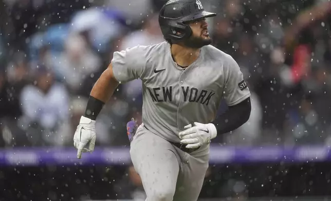 New York Yankees' Jasson Domínguez follows the flight of his sacrifice fly to drive in a run off Colorado Rockies relief pitcher Jake Bird in the top of the fifth inning of a baseball game Sunday, May 25, 2025, in Denver. (AP Photo/David Zalubowski)