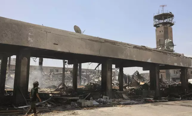 A Yemeni officer inspects the damage following Israeli airstrikes on Sanaa International Airport in Sanaa, Yemen, Wednesday, May 7, 2025. (AP Photo/Osamah Abdulrahman)
