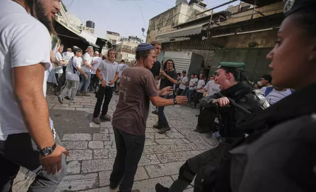 Israeli police scuffle with young Israelis marching through Jerusalem's Old City marking Jerusalem Day, an Israeli holiday celebrating the capture of east Jerusalem in the 1967 Middle East War, Monday, May 26, 2025. (AP Photo/Ohad Zwigenberg)
