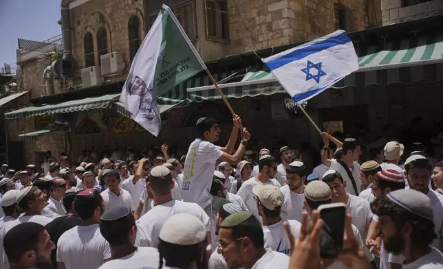 Israelis wave national flags during a march marking Jerusalem Day, an Israeli holiday celebrating the capture of east Jerusalem in the 1967 Mideast war, in Jerusalem's Old City, Monday, May 26, 2025. (AP Photo/Ohad Zwigenberg)