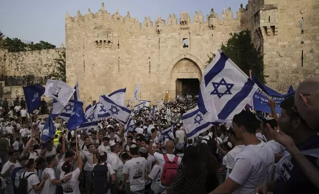 Israelis participate in a march marking Jerusalem Day, an Israeli holiday celebrating the capture of east Jerusalem in the 1967 Mideast war, in Damascus Gate of Jerusalem's Old City, Monday, May 26, 2025. (AP Photo/Leo Correa)