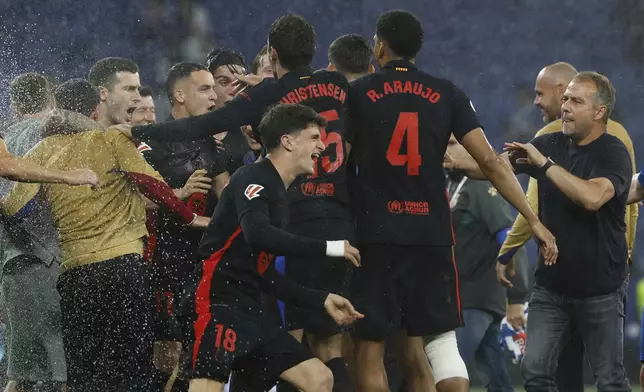 Barcelona players celebrate at the end of the Spanish La Liga soccer match between Barcelona and Espanyol at Lluis Companys Olympic Stadium in Barcelona, Spain, Thursday, May 15, 2025. (AP Photo/Joan Monfort)