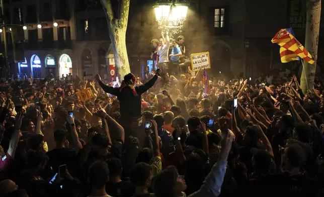 Barcelona fans celebrate in the street after their team won the Spanish La Liga soccer championship in Barcelona, Spain, Thursday, May 15, 2025. (AP Photo/Emilio Morenatti)