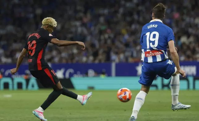 Barcelona's Lamine Yamal attempts a shot at goal to scores his side's opening goal during a Spanish La Liga soccer match between Barcelona and Espanyol at Lluis Companys Olympic Stadium in Barcelona, Spain, Thursday, May 15, 2025. (AP Photo/Joan Monfort)