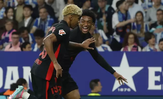 Barcelona's Lamine Yamal, left, celebrates with his teammate Alejandro Balde after scoring his side's opening goal during a Spanish La Liga soccer match between Barcelona and Espanyol at Lluis Companys Olympic Stadium in Barcelona, Spain, Thursday, May 15, 2025. (AP Photo/Joan Monfort)