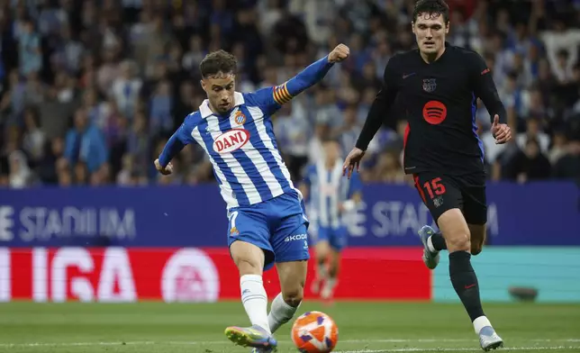 Espanyol's Javi Puado, left, attempts a shot at goal in front of Barcelona's Andreas Christensen during a Spanish La Liga soccer match between Barcelona and Espanyol at Lluis Companys Olympic Stadium in Barcelona, Spain, Thursday, May 15, 2025. (AP Photo/Joan Monfort)