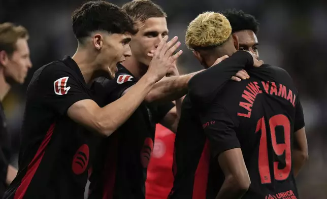 Barcelona players celebrate after a goal during a Spanish La Liga soccer match between Espanyol and Barcelona in Barcelona, Spain, Thursday, May 15, 2025. (AP Photo/Jose Breton)
