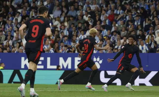 Barcelona's Lamine Yamal, center, celebrates after scoring his side's opening goal during a Spanish La Liga soccer match between Barcelona and Espanyol at Lluis Companys Olympic Stadium in Barcelona, Spain, Thursday, May 15, 2025. (AP Photo/Joan Monfort)