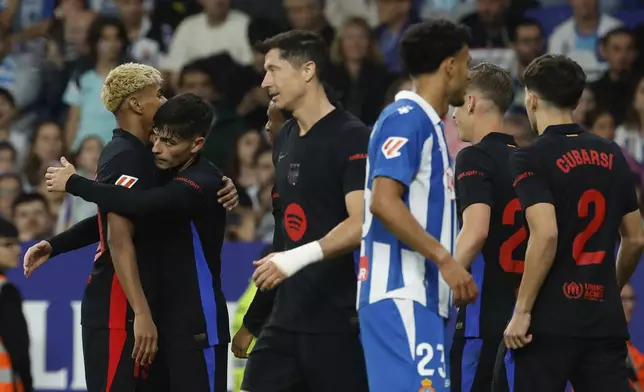 Barcelona's Lamine Yamal, left, celebrates with his teammates after scoring his side's opening goal during a Spanish La Liga soccer match between Barcelona and Espanyol at Lluis Companys Olympic Stadium in Barcelona, Spain, Thursday, May 15, 2025. (AP Photo/Joan Monfort)