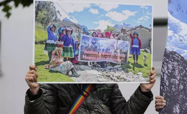 A protestor demands climate justice in front of the Higher Regional Court in Hamm, Germany, ahead of the verdict in the climate lawsuit brought by Peruvian farmer Luciano Lliuya against German energy company RWE, Wednesday, May 28, 2025. (AP Photo/Martin Meissner)
