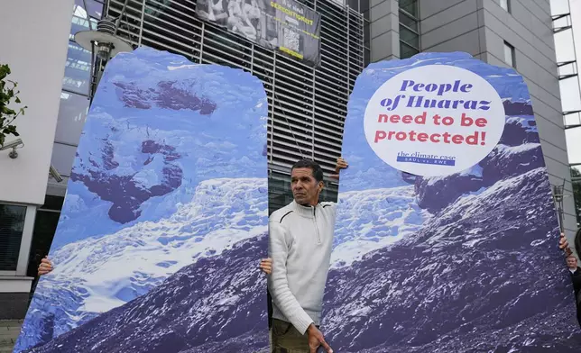 A protestor demands climate justice in front of the Higher Regional Court in Hamm, Germany, ahead of the verdict in the climate lawsuit brought by Peruvian farmer Luciano Lliuya against German energy company RWE, Wednesday, May 28, 2025. (AP Photo/Martin Meissner)
