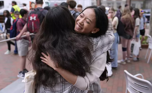 Yurong "Luanna" Jiang, who delivered a speech at her Harvard University commencement, smiles while embracing her friend Helen Ji, Friday, May 30, 2025, in Cambridge, Mass. (AP Photo/Charles Krupa)