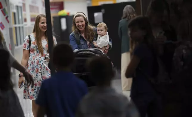 Joi Rogers walks into church with one of her children on Sunday, April 6, 2025, at Pillar Church in Dumfries, Va. (AP Photo/Jessie Wardarski)