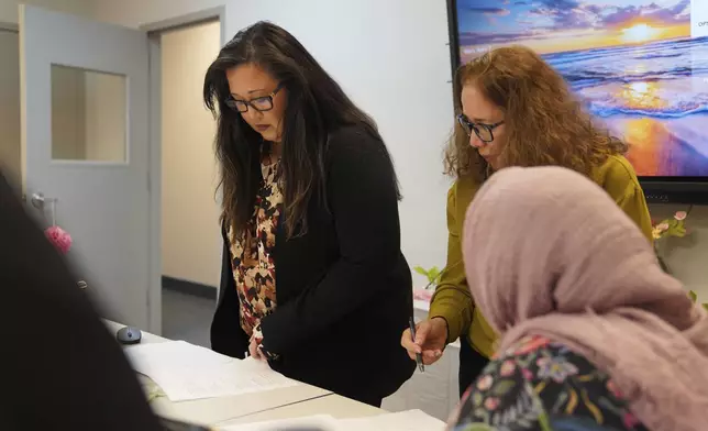 Kat Renfroe, a supervisor at Catholic Charities Migrant and Refugee Services, left, observes an Afghan refugee women's group at their offices in Fredericksburg, Va., on Tuesday, April 8, 2025. (AP Photo/Jessie Wardarski)
