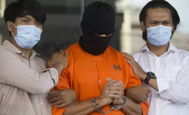 An Australian man arrested for allegedly smuggling cocaine stands escorted during a news conference at the police headquarters in Bali, Indonesia, Monday, May 26, 2025. (AP Photo/Firdia Lisnawati)