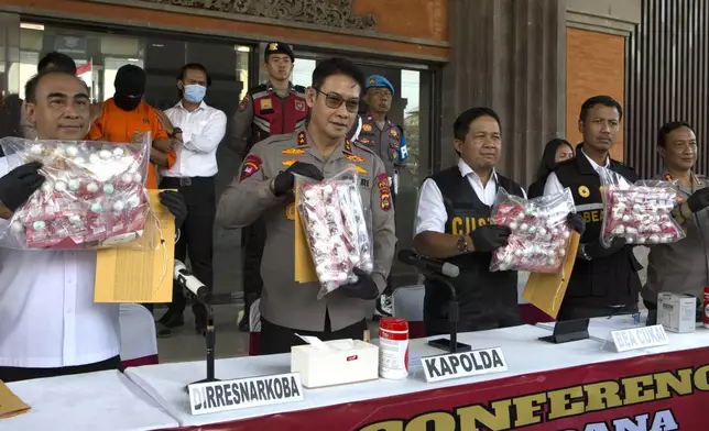 Authorities hold a news conference as an Australian man, second left in the background, arrested for allegedly smuggling cocaine stands at the police headquarters in Bali, Indonesia, Monday, May 26, 2025. (AP Photo/Firdia Lisnawati)