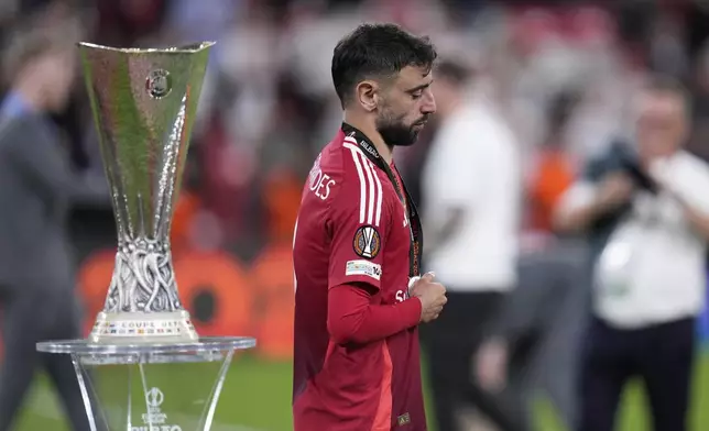 Manchester United's Bruno Fernandes walks past the trophy at the end of the Europa League final soccer match between Tottenham Hotspur and Manchester United at the San Mames Stadium in Bilbao, Spain, Wednesday, May 21, 2025. (AP Photo/Bernat Armangue)
