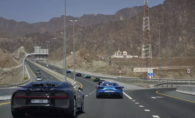 Supercars drive down the road during the first all-women rally in Dubai, United Arab Emirates, Thursday, May 1, 2025. (AP Photo/ Fatima Shbair)
