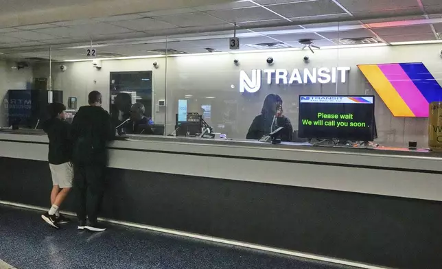 People stand at the train ticket counter of NJ Transit at Penn Station, amid a strike by New Jersey Transit train engineers, in New York, Friday, May 16, 2025. (AP Photo/Richard Drew)