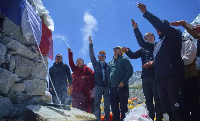 Kami Rita Sherpa, third left, who holds the record for most ascents to Mount Everest, prays with other mountaineers at Everest Base Camp before beginning his ascent to the summit of Mount Everest in Nepal, April 24, 2025. (AP Photo/Pasang Rinzee Sherpa)
