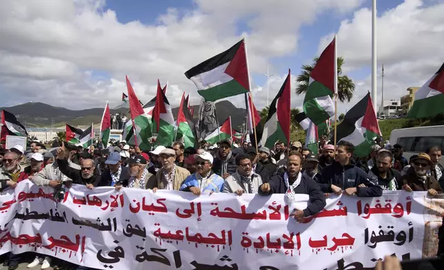 Moroccans protest the docking of a Maersk cargo ship carrying airplane parts they suspect are headed to Israel, outside Tangier Med Port, Sunday, April 20, 2025. Banner in Arabic reads "Stop shipping weapons to the terrorist Zionist entity." (AP Photo/Mosa'ab Elshamy)