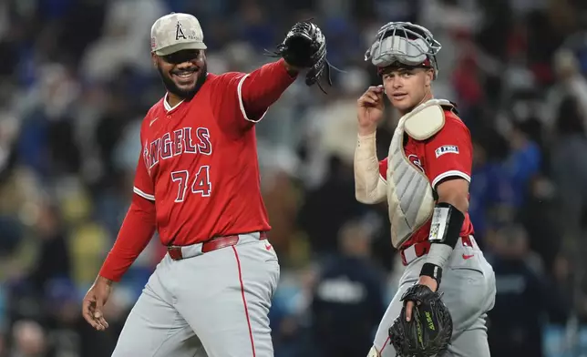 Los Angeles Angels relief pitcher Kenley Jansen, left gestures toward the Los Angeles Dodgers dugout as catcher Logan O'Hoppe looks on after the Angels defeated the a dodgers 11-9 in a baseball game Saturday, May 17, 2025, in Los Angeles. (AP Photo/Mark J. Terrill)
