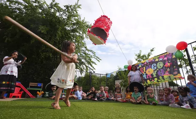 Victoria Jasso, 2, swings at a piñata during a Cinco de Mayo celebration at the Yorktown Spanish School in Dallas, Monday, May 5, 2025. (AP Photo/LM Otero)