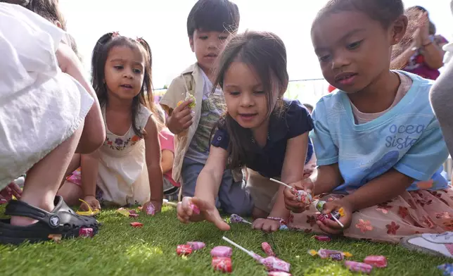Children pick up candy during a Cinco de Mayo celebration at the Yorktown Spanish School in Dallas, Monday, May 5, 2025. (AP Photo/LM Otero)