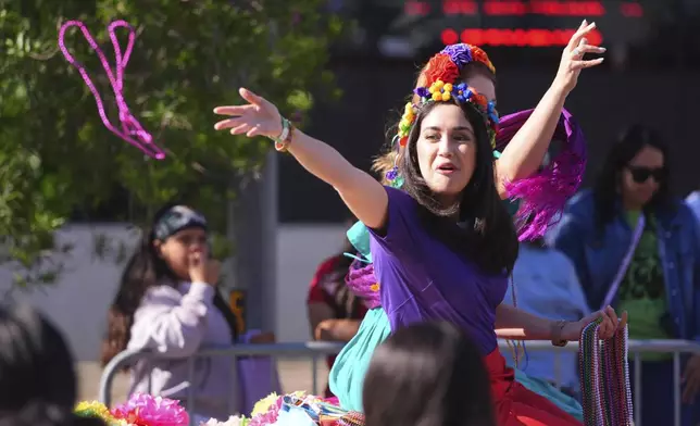Beads are tossed from a float during a Cinco de Mayo parade in the Oak Cliff section of Dallas, Saturday, May 3, 2025. (AP Photo/LM Otero)