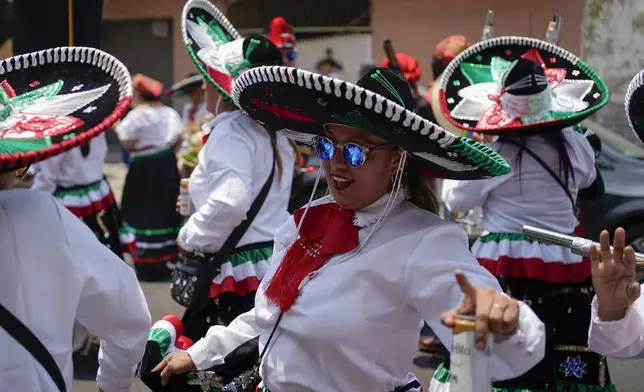 FILE - Women dance during a re-enactment of The Battle of Puebla as part of Cinco de Mayo celebrations in the Peñon de los Baños neighborhood of Mexico City, May 5, 2022. (AP Photo/Eduardo Verdugo, File)
