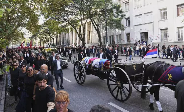 The funeral procession for the late former President Jose Mujica makes its way from the presidential palace to the National Assembly in Montevideo, Uruguay, Wednesday, May 14, 2025. (AP Photo/Matilde Campodonico)