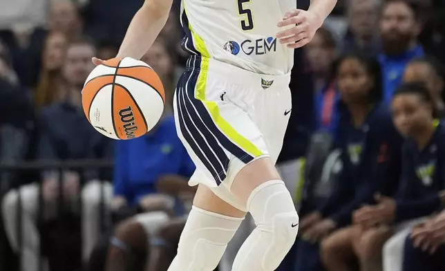 Dallas Wings guard Paige Bueckers (5) dribbles down the court during the first half of a WNBA basketball game against the Minnesota Lynx, Wednesday, May 21, 2025, in Minneapolis. (AP Photo/Abbie Parr)
