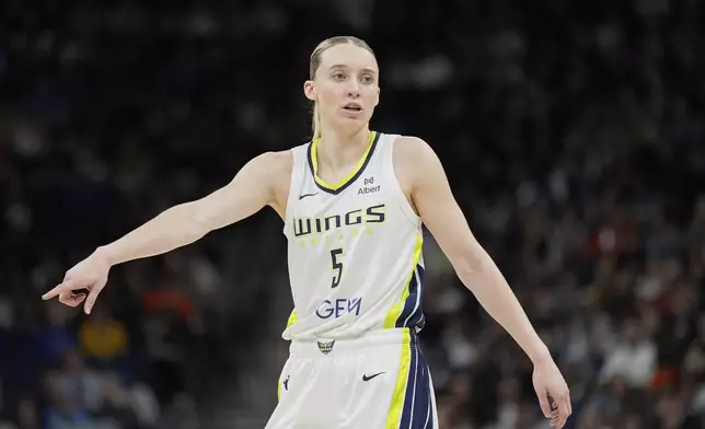 Dallas Wings guard Paige Bueckers (5) points during the first half of a WNBA basketball game against the Minnesota Lynx, Wednesday, May 21, 2025, in Minneapolis. (AP Photo/Abbie Parr)