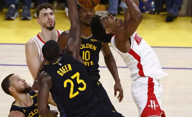 Houston Rockets forward Amen Thompson, right, is blocked by Golden State Warriors forward Draymond Green (23) in the second quarter of Game 6 of an NBA basketball first-round playoff series Friday, May 2, 2025, in San Francisco. (Santiago Mejia/San Francisco Chronicle via AP)