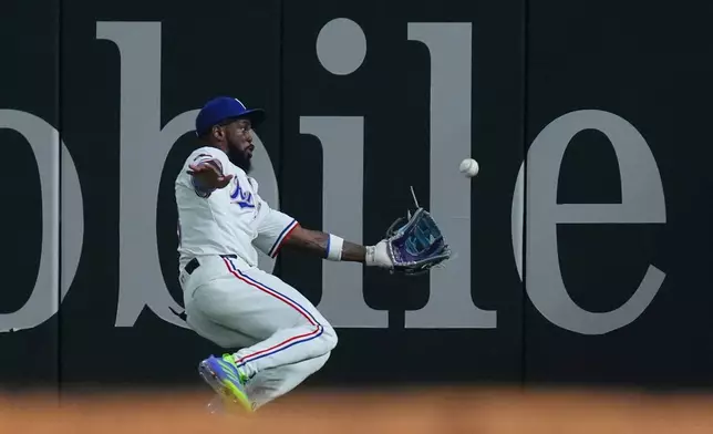Texas Rangers outfielder Adolis García catches a fly out against Houston Astros' Isaac Paredes during the fourth inning of a baseball game, Thursday, May 15, 2025, in Arlington, Texas. (AP Photo/LM Otero)