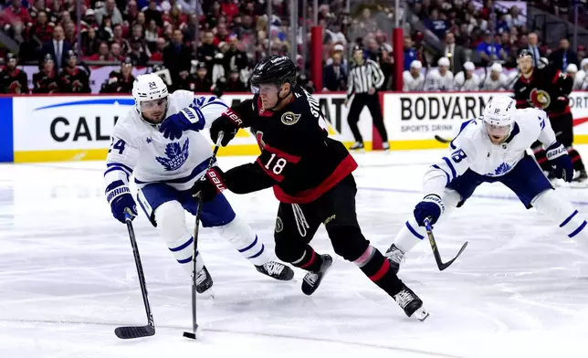 Ottawa Senators' Tim Stutzle (18) shoots against Toronto Maple Leafs' Scott Laughton (24) and Steven Lorentz (18) during the second period of Game 6 of a first-round NHL hockey playoff series in Ottawa, Ontario, Thursday, May 1, 2025. (Justin Tang/The Canadian Press via AP)