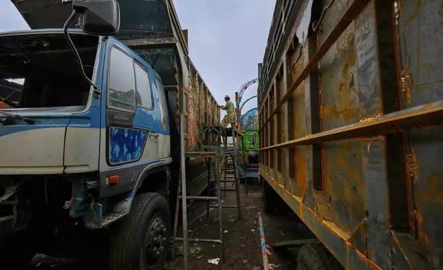 A welder repairs a truck parked at a yard for workshops in Rawalpindi, Pakistan, on Saturday, April 19, 2025. (AP Photo/Anjum Naveed)