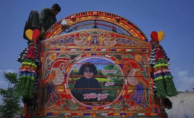 A worker gives the final touches to a newly refurbished truck at a yard for workshops in Rawalpindi, Pakistan Thursday, April 24, 2025. (AP Photo/Anjum Naveed)